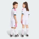 Primera equipación para niño del Real Madrid temporada 2027. Conjunto completo de camiseta y pantalón corto blancos oficiales.
