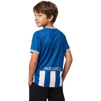 Conjunto de la primera equipación del Deportivo de La Coruña para niños, temporada 2026-2027, con la camiseta blanquiazul y pantalón.