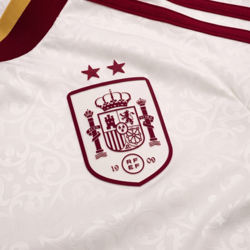 Detalle del escudo y las dos estrellas de campeón en la camiseta visitante de la Selección Española de fútbol para 2026.