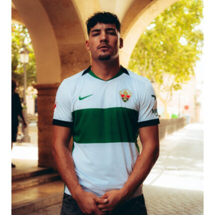 Camiseta de la primera equipación del Elche CF para la temporada 2026/2027, versión de adulto. Color blanco con franja verde.