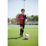 Primera equipación oficial del RCD Mallorca para niños, temporada 2026-2027. Kit completo de camiseta y pantalón rojo y negro.