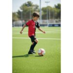 Primera equipación oficial del RCD Mallorca para niños, temporada 2026-2027. Kit completo de camiseta y pantalón rojo y negro.