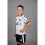 Primera equipación oficial del Burgos CF para niños de la temporada 26/27. Camiseta y pantalón blancos con detalles del club.