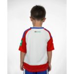 Primera equipación del Granada CF para niños temporada 2026-27. Conjunto de camiseta y pantalón oficial para los más pequeños.