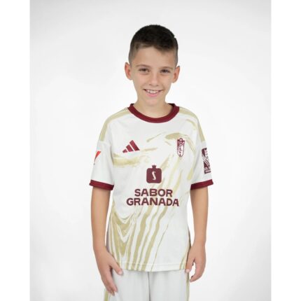 Vista frontal de la tercera equipación de fútbol del Granada CF para niños de la temporada 26-27. Incluye camiseta y pantalón.