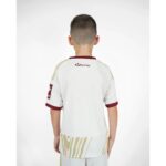 Vista frontal de la tercera equipación de fútbol del Granada CF para niños de la temporada 26-27. Incluye camiseta y pantalón.