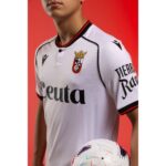 Camiseta oficial de la primera equipación del AD Ceuta FC para la temporada 2026/27. Modelo de adulto con diseño blanquinegro.