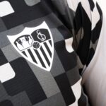Vista frontal de la camiseta Prematch del Sevilla FC para hombre, temporada 26/27. Diseño en color negro con escudo del club bordado.