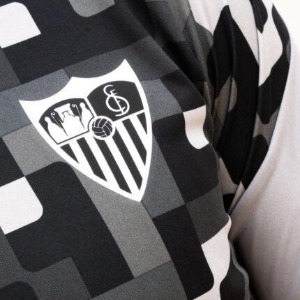 Vista frontal de la camiseta Prematch del Sevilla FC para hombre, temporada 26/27. Diseño en color negro con escudo del club bordado.